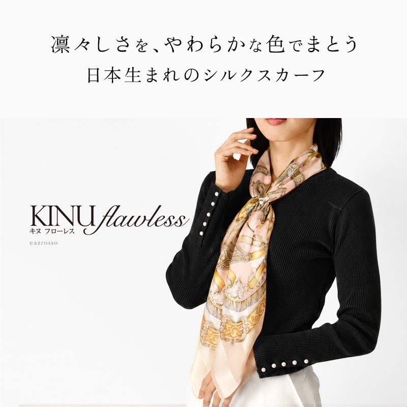 黒のリブニットにベージュローズの馬具柄シルクスカーフを合わせ、首元から長く垂らした着用例。キヌフローレス