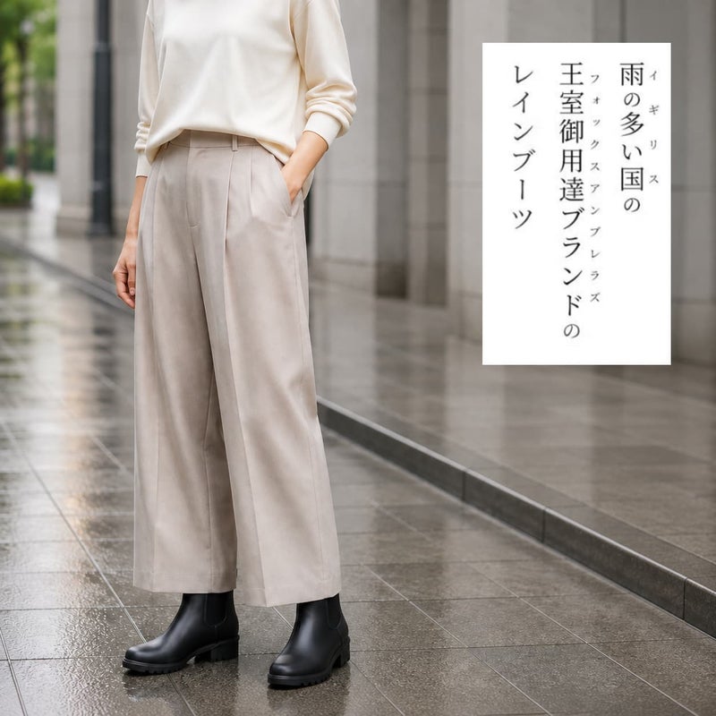 ブラックのサイドゴアレインブーツに、白のトップスとベージュのワイドパンツを合わせた雨の日のコーディネート