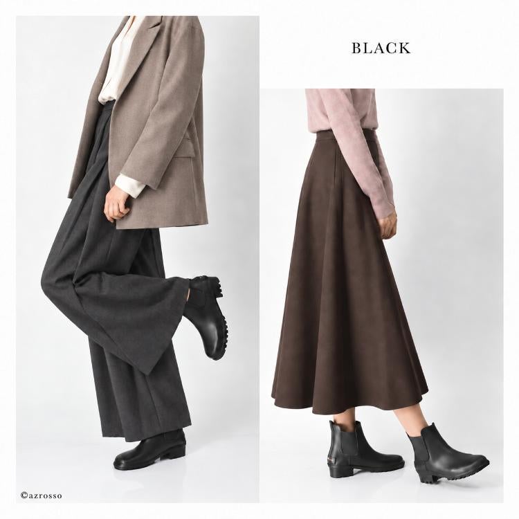 ブラックのレインブーツの着用例。オーバーサイズジャケットとワイドパンツ、ピンクのニットとブラウンのフレアスカート
