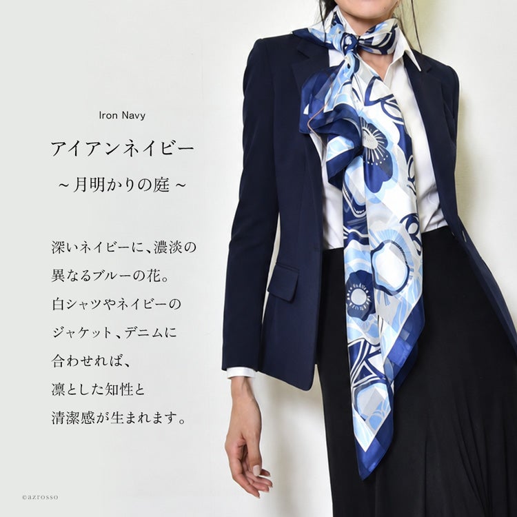 ネイビージャケットと白シャツに、ブルーの花柄シルクスカーフを長く垂らした通勤コーデ。アイアンネイビーの着用例