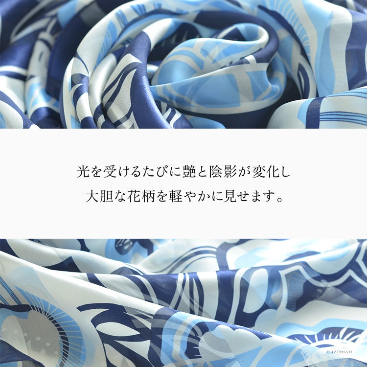 ネイビーの花柄シルクスカーフを波打たせた生地のアップ。ひだに沿って変わる光沢と陰影、薄地の透け感