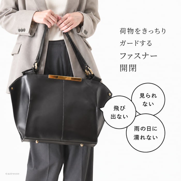ジャケットに合わせた黒の本革ビジネストートの手持ち例。通勤時の荷物を覆うファスナー開閉仕様