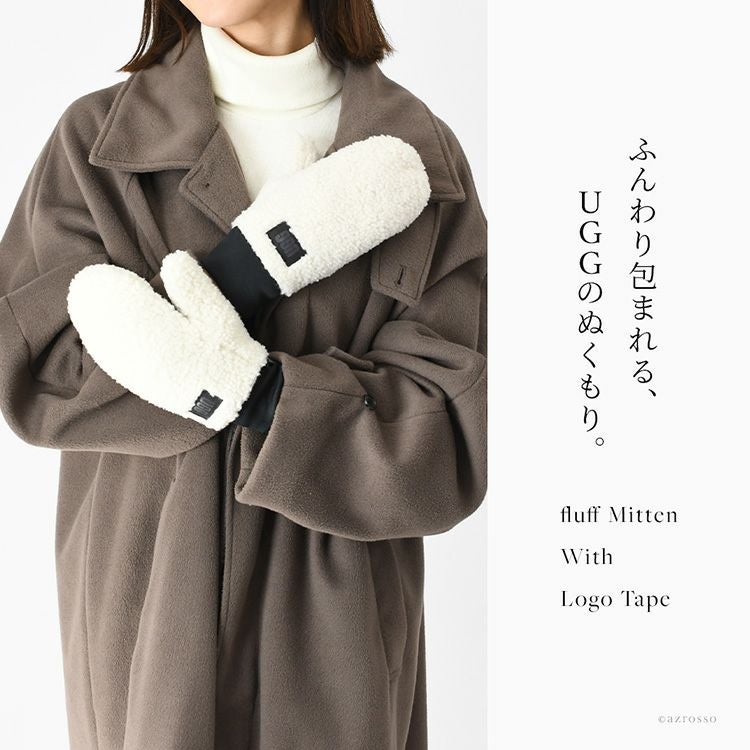 UGGのもこもこ暖かいミトン手袋を着用した女性モデル。おしゃれなブランドロゴパッチがアクセントの秋冬向けレディースミトングローブ。