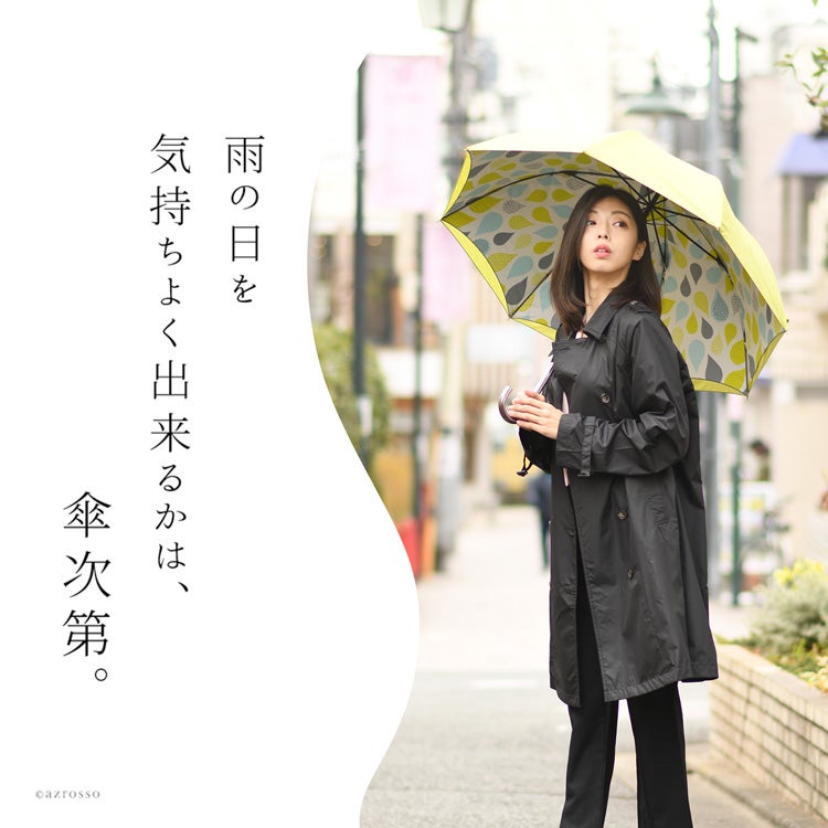ティアドロップ柄の二重張りがかわいいルビアレインの晴雨兼用傘を差す大人の女性。荷物がある時もボタン一つでスムーズに開くワンタッチジャンプ式の長傘。