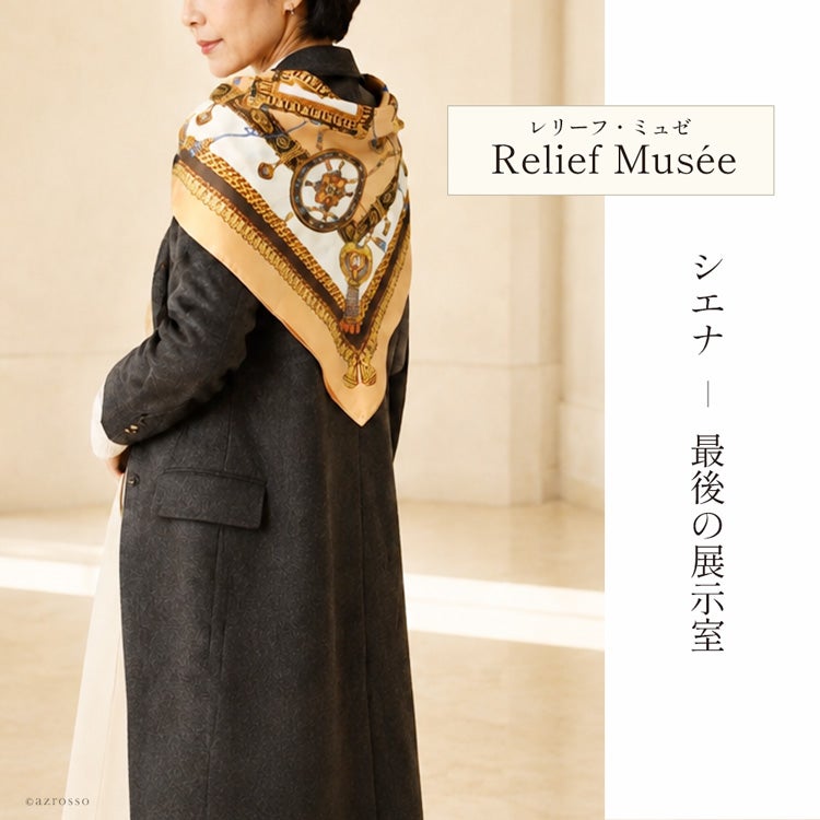 チャコールグレーのコートに、馬具柄の大判シルクスカーフを三角形に肩掛けした後ろ姿。「レリーフ・ミュゼ」の着用例