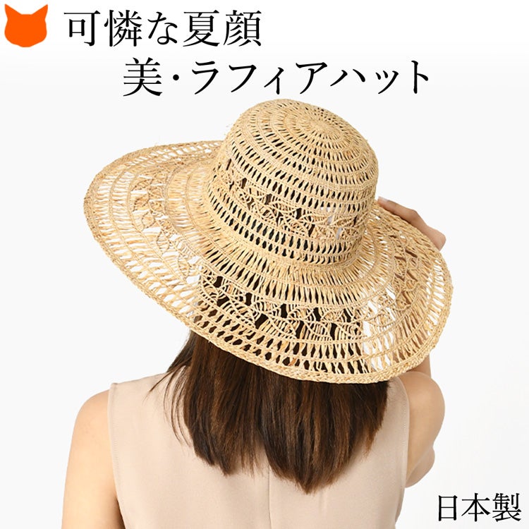 ラフィア帽子 レディース 夏用。つば広デザインで日よけも叶える、日本製（アトリエブルージュ）の上質なサマーハットをかぶった女性。