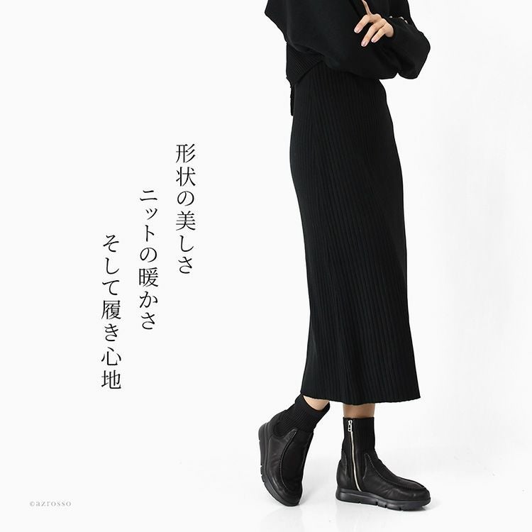 黒のショートブーツを履いた女性。日本製の4E幅広仕様で、細見えするモネ（monet）のショートブーツ。超軽量で歩きやすく、ロングスカートにも合わせやすい上品なコーデ。