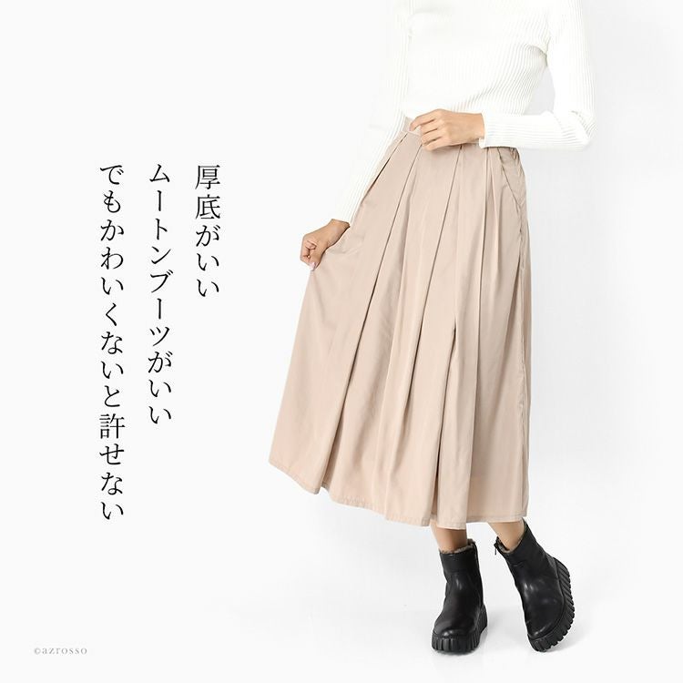 ガボール Gabor の厚底ムートンショートブーツ 黒 を着用した女性コーデ。ベージュのスカートと合わせたきれいめスタイル。内ボア付きの本革ブーツは超軽量で歩きやすく、40代・50代女性にも人気。