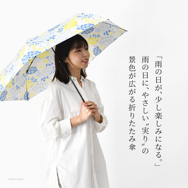 北欧デザインの大人かわいいムーミンとリトルミイのキャラクター傘(折りたたみ雨傘)を差しながら歩く笑顔の女性。