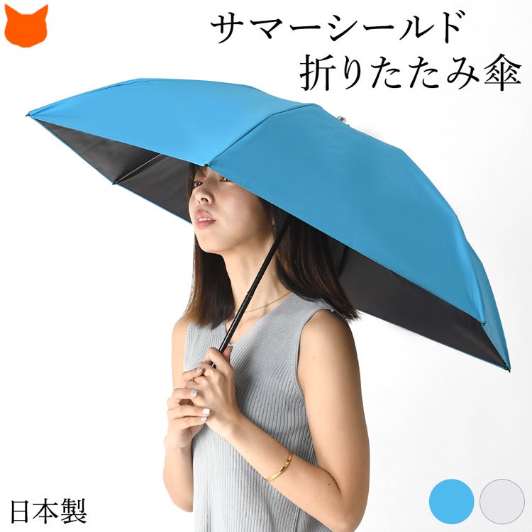 サマーシールドの高い遮光性と東レカーボンのしなやかな強さを一本に。約190gの軽量でかさばらない薄型フラットな日本製の完全遮光・晴雨兼用折りたたみ日傘を差す女性