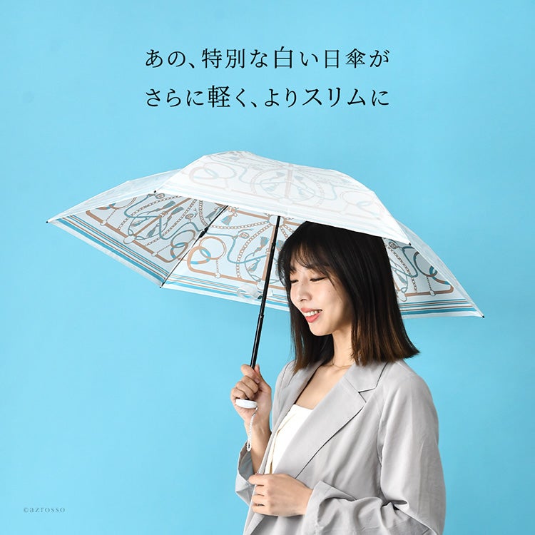 あの特別な白い日傘が、さらに軽く、よりスリムに。遮熱とUVカット率99％以上でひんやり涼しい日本製「プレミアムホワイト」の晴雨兼用日傘（タッセルベルト柄）を差して歩く大人の女性