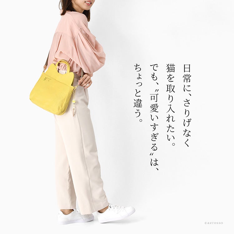 さりげない猫モチーフで大人の女性に似合うショルダーハンドバッグ。A5サイズやペットボトルも入る収納力を備えた本革（姫路レザー）の日本製猫バッグを斜めがけする女性の着用イメージ