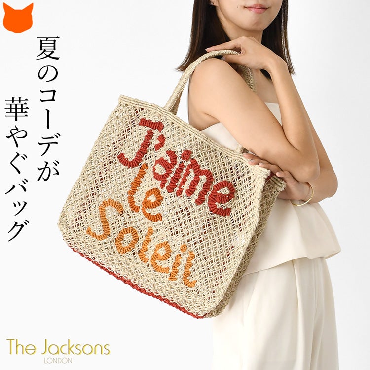 夏のシンプルコーデが華やぐジャクソンズの大容量ジュートバッグ。A4サイズやたっぷり荷物が入る大きめサイズで、ブラッドオレンジ系の文字が目を惹くトートバッグを肩掛けする女性