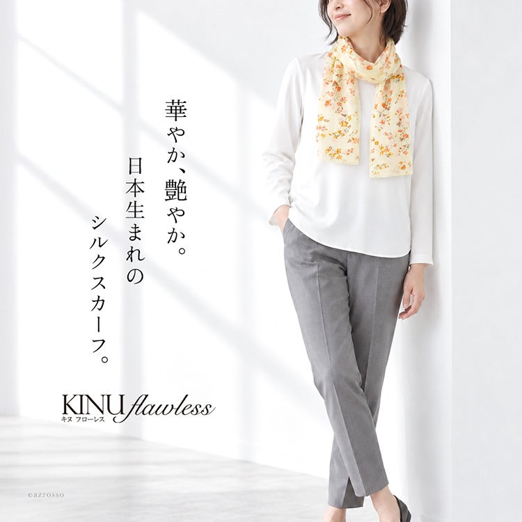 小さな花々を散りばめた花柄のシルク100%サテンロングスカーフ（日本製・横浜スカーフ）を首元に巻いた女性モデル