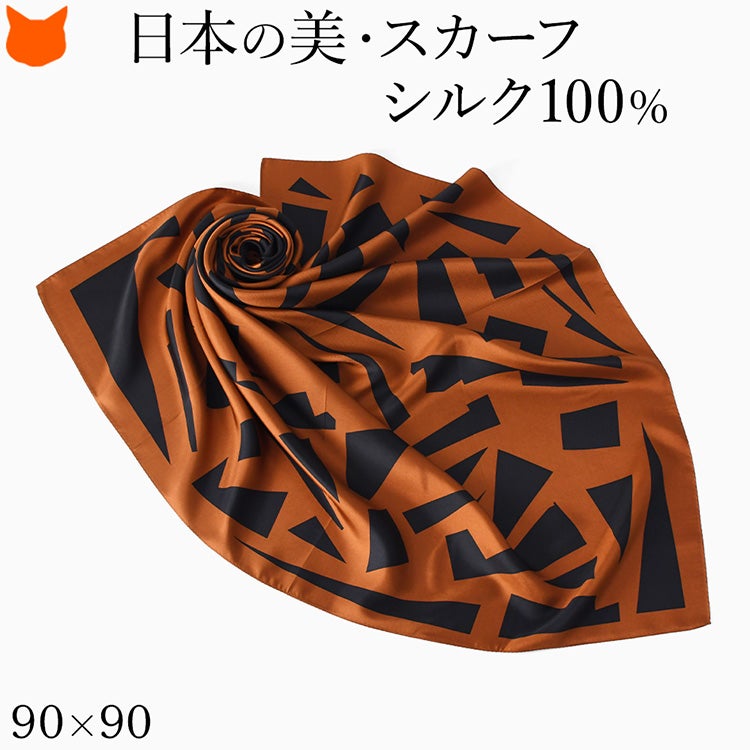 大小の幾何学モチーフを描いたカッパーブラウンのスカーフ。キヌフローレスの日本製シルク100％ツイル、90cm角