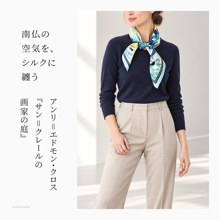 ネイビーのニットに、青緑やイエロー、パープルの水彩柄スカーフを合わせた着用イメージ。アンリ＝エドモン・クロスの作品をモチーフにしたマルフロイのシルクスカーフ